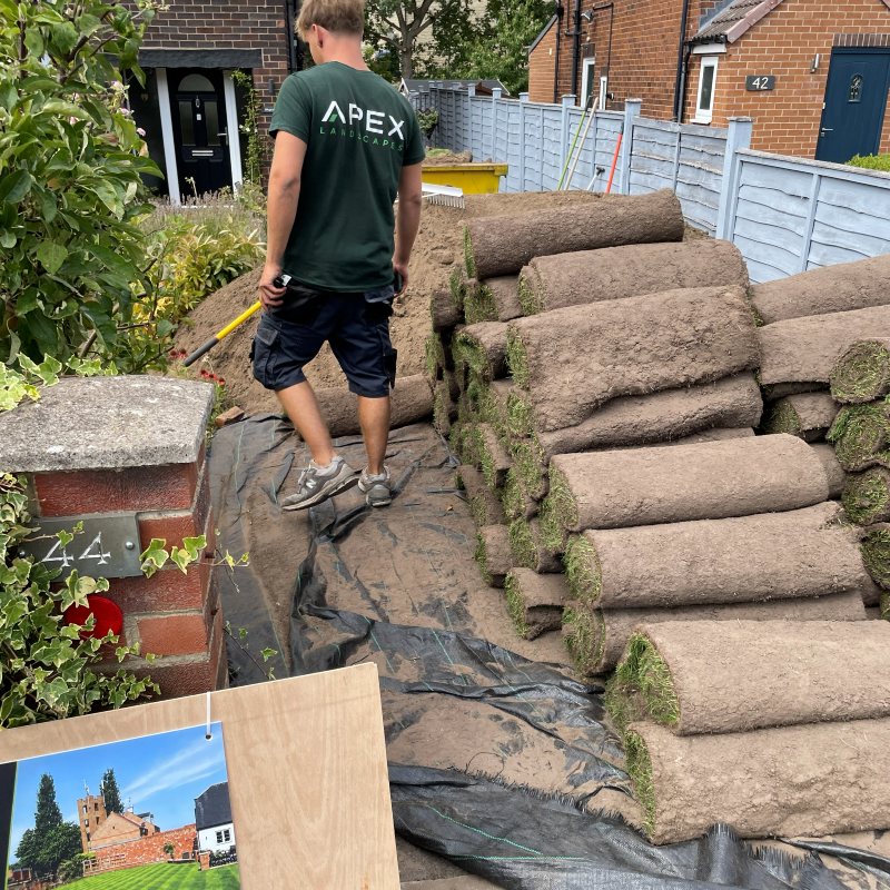 Apex Landscapes team member in branded workwear unloading turf