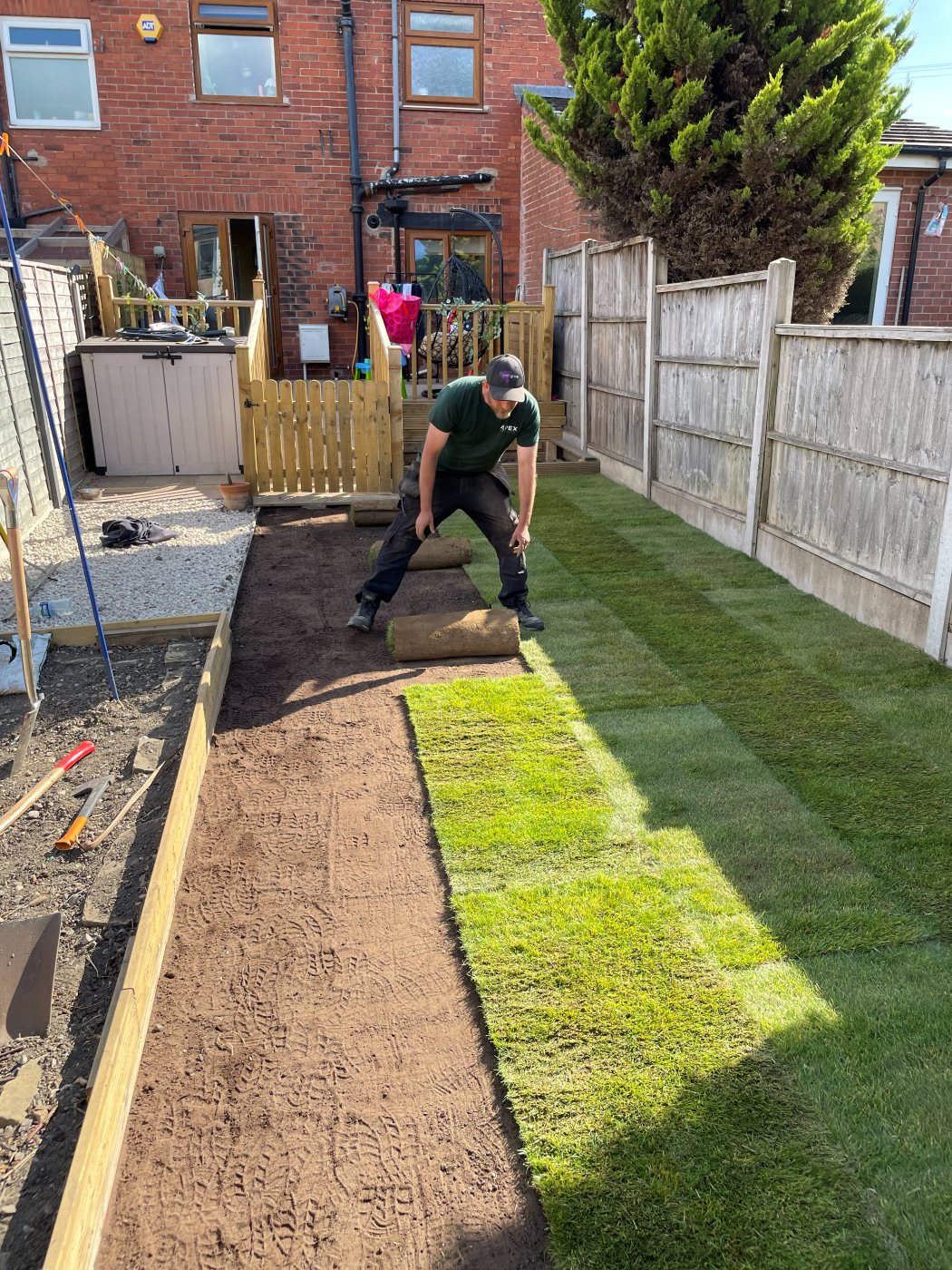Apex Landscapes team laying fresh turf rolls in a North Leeds garden