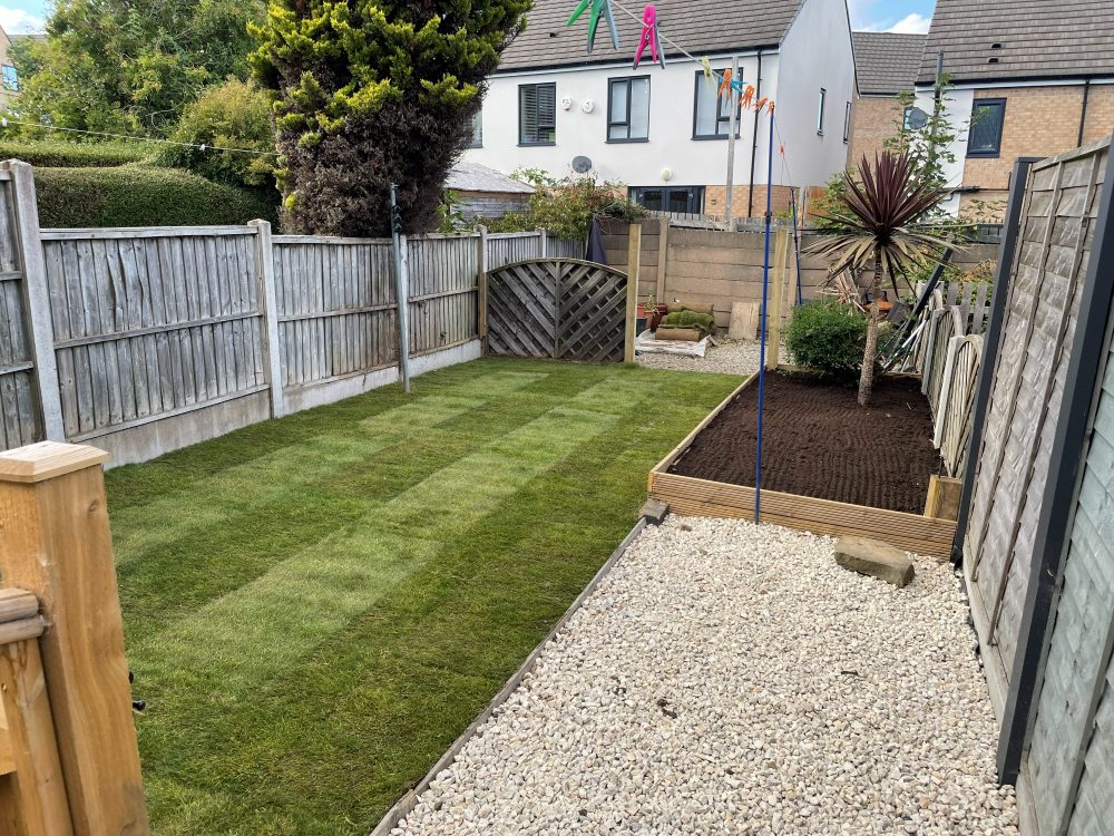 New lawn with sleeper raised bed and gravel border in a Leeds back garden