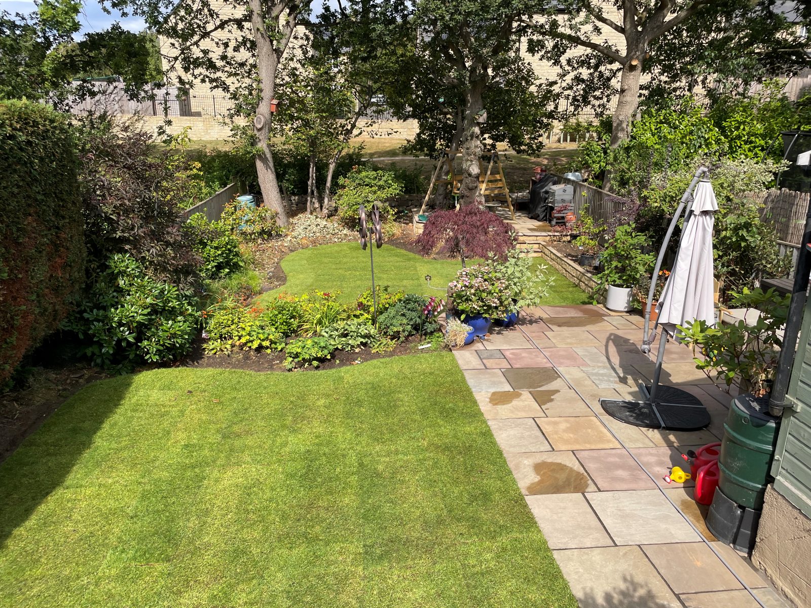 New turf lawn in a mature garden with stone patio, North Leeds