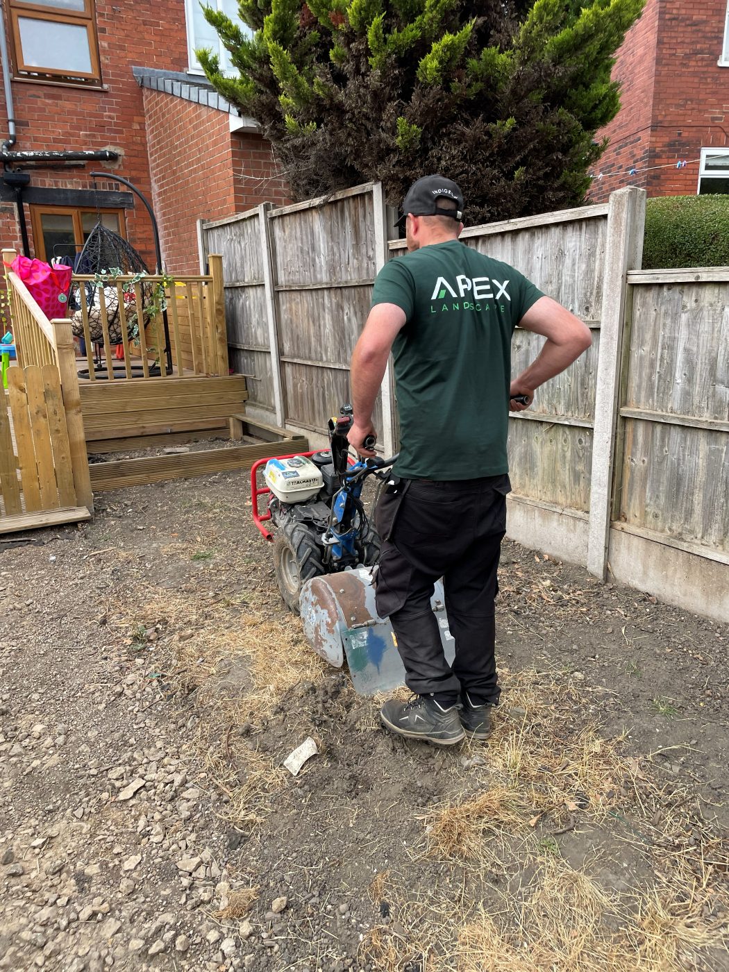 Apex Landscapes team member rotavating a garden ready for new turf
